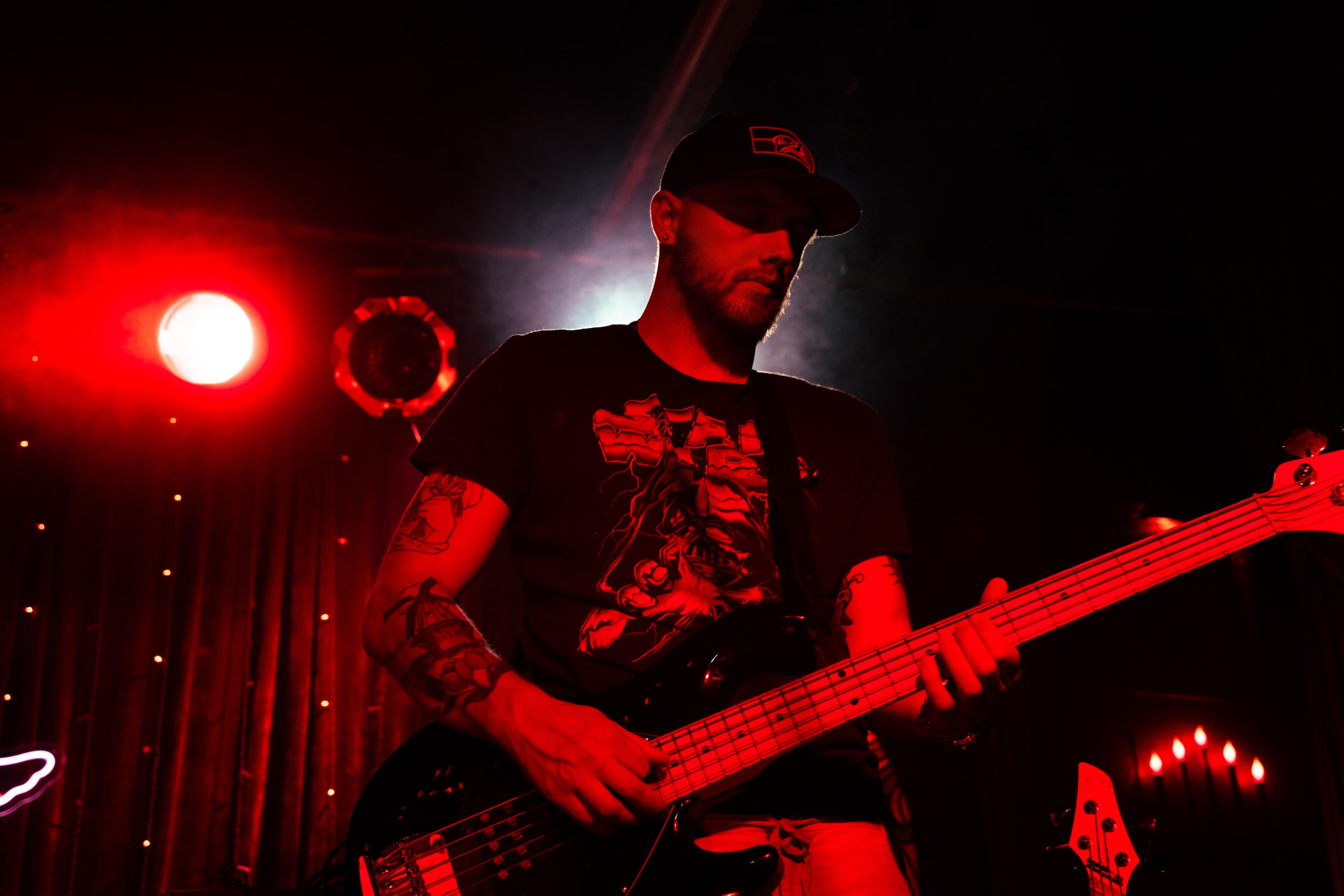 Rise Up Revival bass player under red stage lights